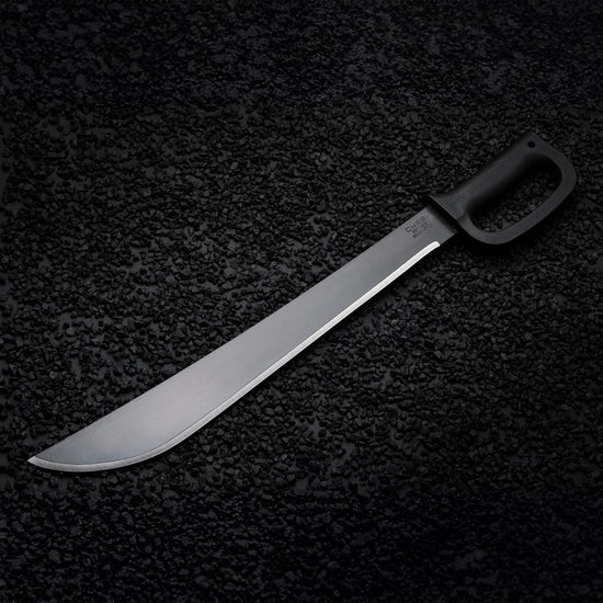 Heavy-duty Okapi D-Ring machete with protective Tactical Black grip displayed in nature