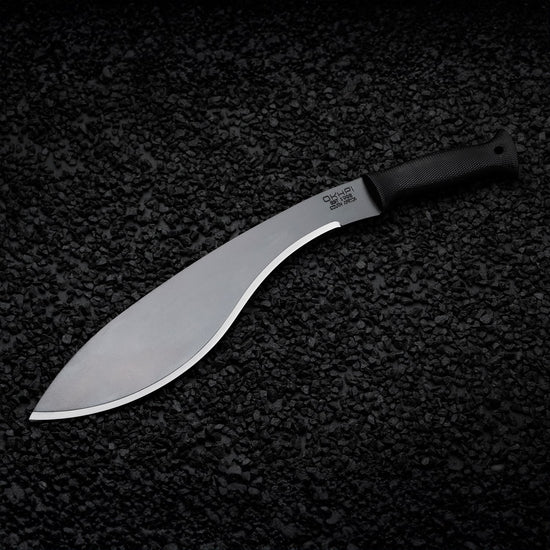Curved Okapi Kukri machete with black grip featured on rugged rock floor scene