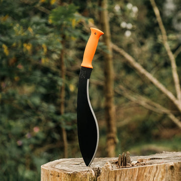 Okapi Orange handled Okapi Kukri machete positioned in a wilderness setting