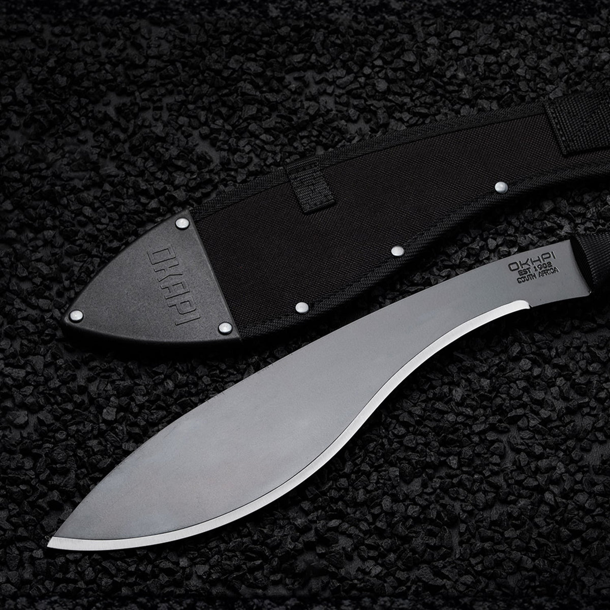 Okapi Kukri Machete Sheath in black on a black stone flooring