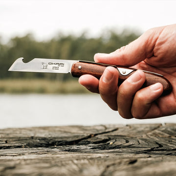 Handheld Okapi Biltong & Beer Knife with a wooden handle in wildlife background