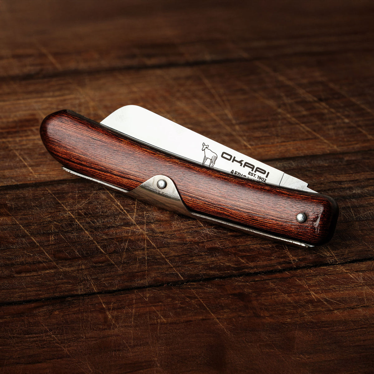 Close-up Okapi Biltong Knife folded on wooden background