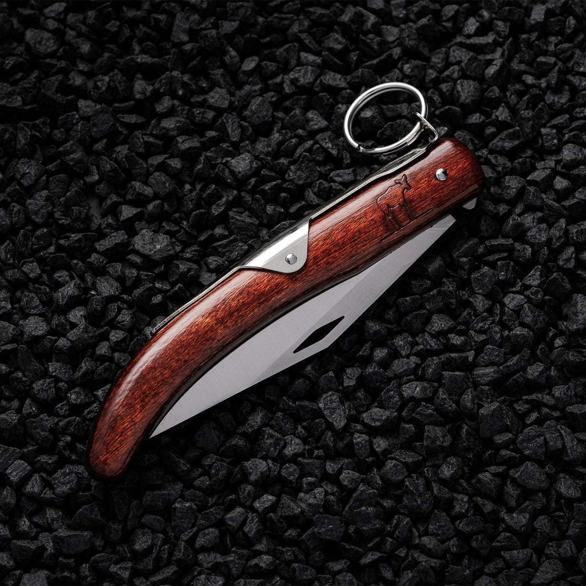 Folded Okapi Lock Knife with wooden handle on black stone background